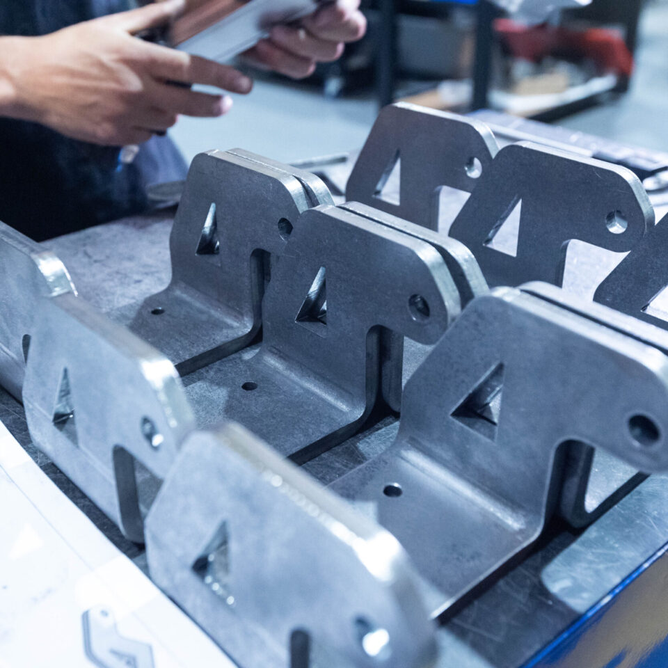 Close-up of machined metal parts on a workbench, showcasing the ability to work with various types of metals.